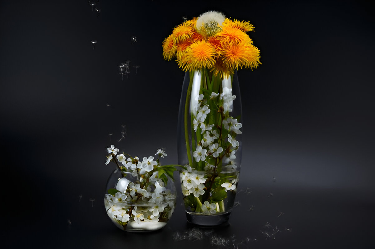 Spring flowers. Glass vases with water, dandelions and cherry blossoms.